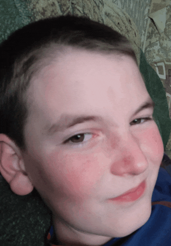 a close up of a young boy 's face with a red nose