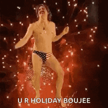 a man in underwear is dancing in front of fireworks .