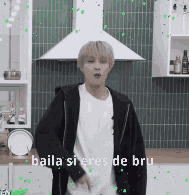 a man is dancing in a kitchen with the words baila si eres de bru written on the bottom