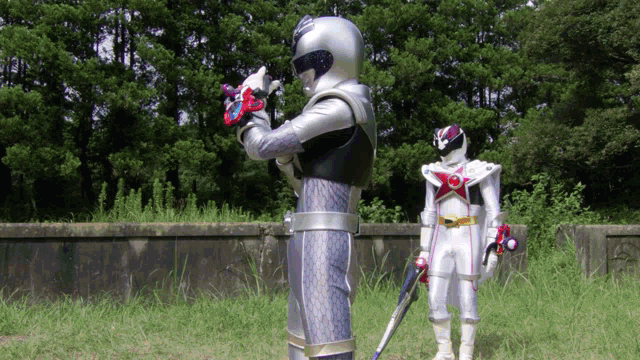 a silver and black superhero standing next to a white superhero holding a sword