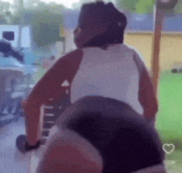 a woman in a white tank top and black shorts is doing a butt flip on a machine .