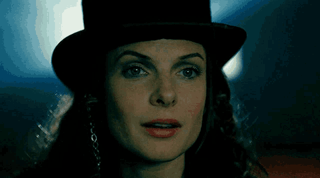 a close up of a woman wearing a black top hat