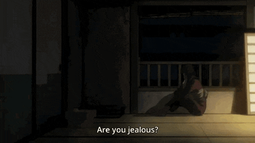 a man in a kimono is sitting on the floor next to a woman in a red dress .