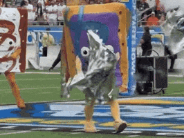 a person in a spongebob costume is walking on a field .