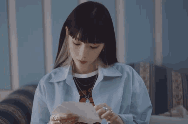 a woman sitting on a couch looking at a piece of paper that says ' united states of america '