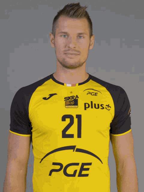a man is wearing a yellow and black pge shirt