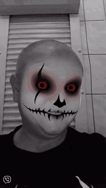 a person with a skeleton face paint and red eyes