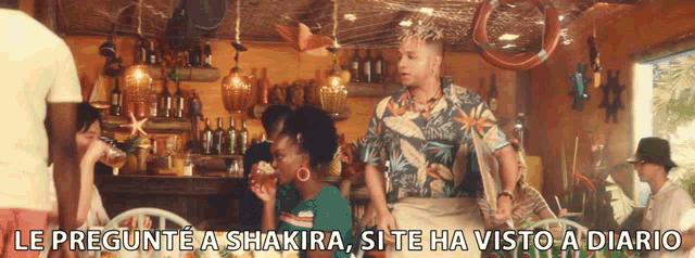 a group of people sitting at a table with the words le pregunte a shakira si te ha visto a diario written below them