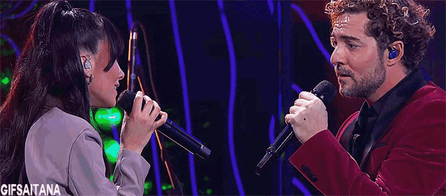 a man and a woman singing into microphones with a gifsaitana watermark