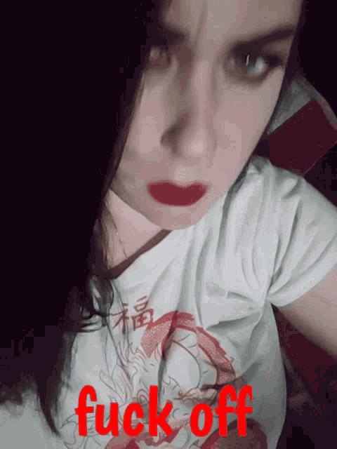 a woman wearing a white shirt that says fuck off on it