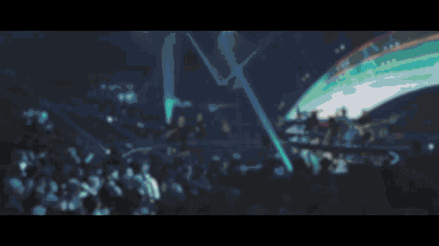 a blurry image of a man playing a guitar on stage