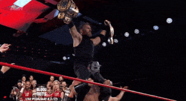 a group of wrestlers are standing in a ring with the word blood guts on the bottom