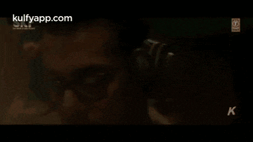 a man wearing headphones is standing in front of a microphone .