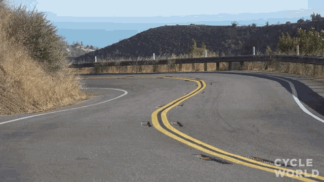 a curvy road with the words cycle world on the bottom right