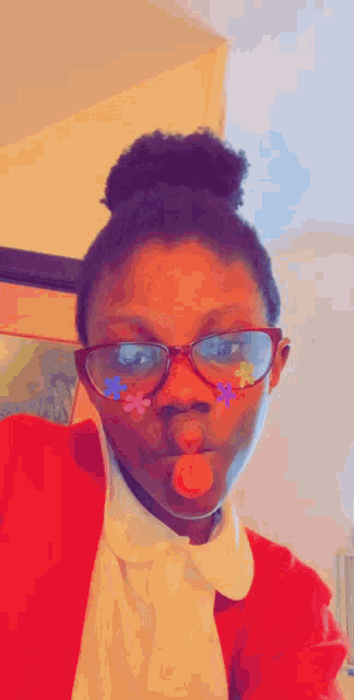 a girl wearing glasses and a red jacket has flowers painted on her face
