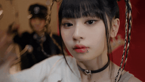 a girl with a piercing in her lip is wearing a choker with a heart on it