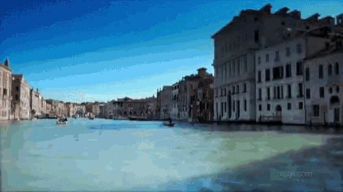a blurred image of a river with buildings in the background and the website acqua.com in the corner