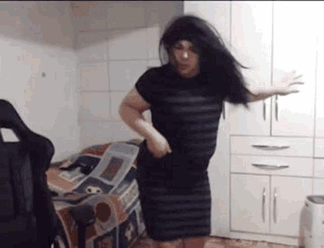 a man in a striped dress is dancing in a bedroom .