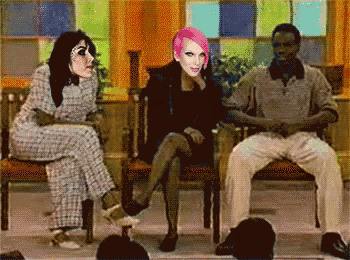 a woman with pink hair sits between two men
