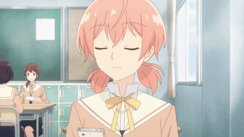 a girl with pink hair is sitting in a classroom