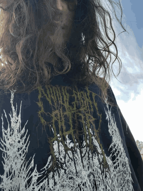 a person with long hair is wearing a black shirt that says ' apocalypse '