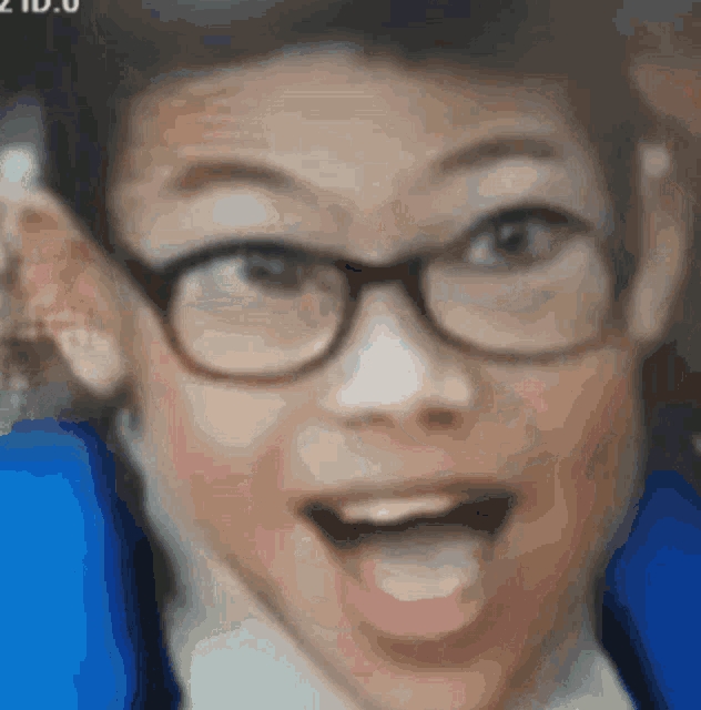 a close up of a boy wearing glasses and a blue jacket .