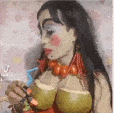 a woman is drinking from two coconuts with straws .