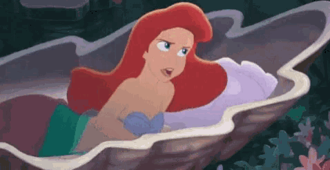 ariel is sitting in an oyster shell in the little mermaid .