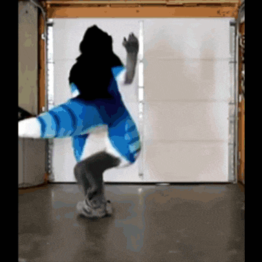 a person in a blue and white outfit is dancing in a garage