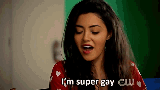 a woman says " i 'm super gay " in front of a cw logo