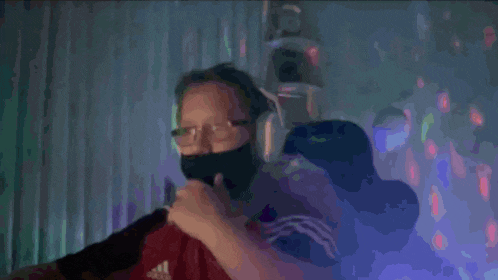 a man wearing a mask and headphones is singing into a microphone ..