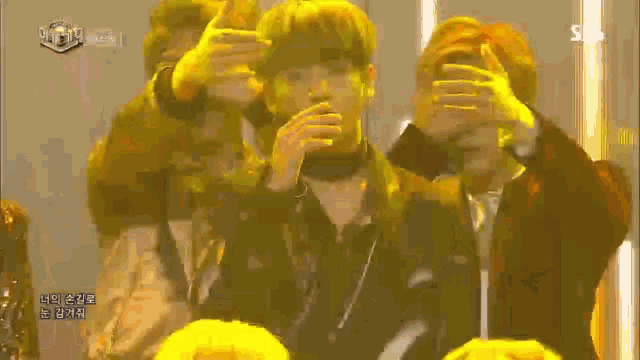 a group of people covering their eyes with their hands