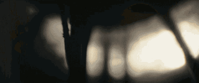 a blurred image of a tree with a few lights behind it