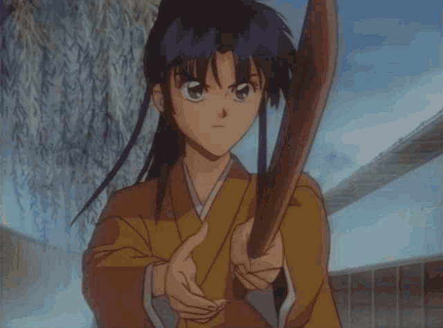a boy in a kimono holds a sword in his hands