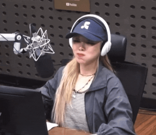 a woman wearing headphones and a baseball cap with a letter s on it