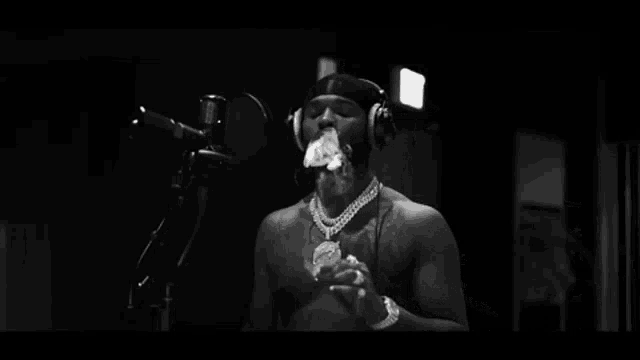 a man is smoking a cigarette in front of a microphone .