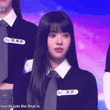 a girl with long black hair and a name tag that says " survivor to join the final "