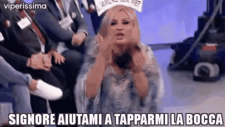 a woman is sitting in front of a group of people with a sign on her head that says signor