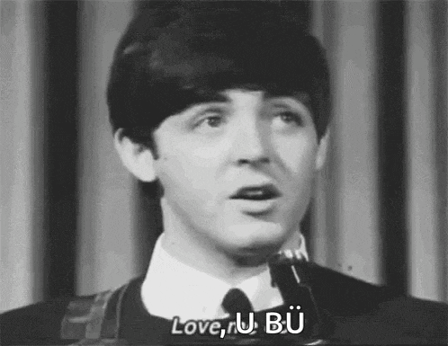 a black and white photo of a man singing into a microphone with the words `` love u bu '' .