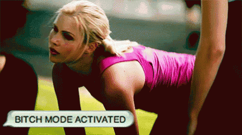 a woman in a pink shirt is doing push ups with a sign that says bitch mode activated above her