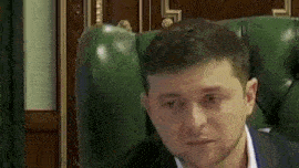 a man in a suit and white shirt is sitting in a green leather chair .