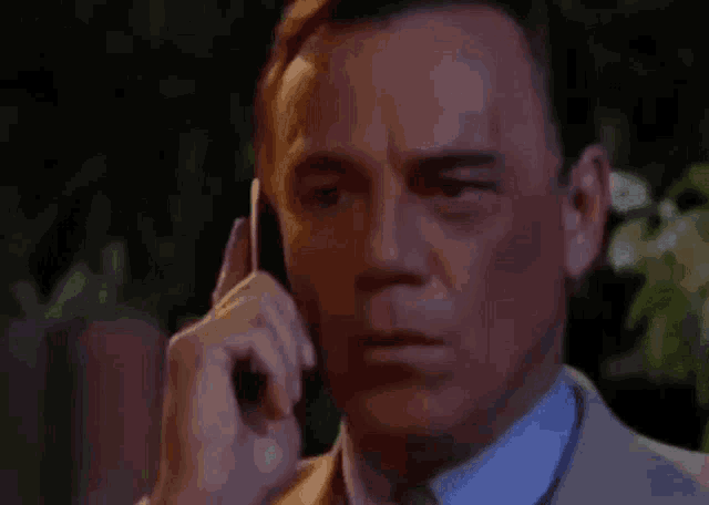 a man talking on a cell phone with his eyes closed