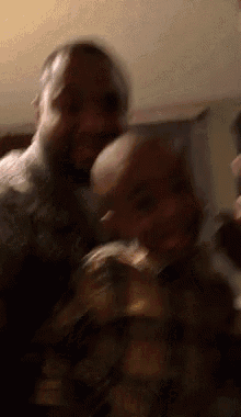 a man with a beard is holding a baby in his arms in a blurry photo .
