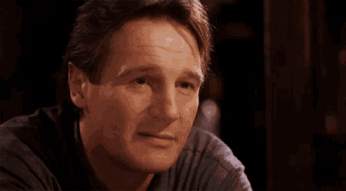 a close up of a man 's face looking at the camera with a serious look on his face .