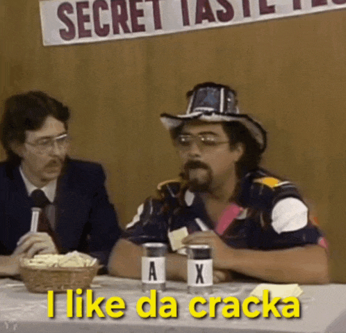 two men are sitting at a table and one of them is saying i like da cracka