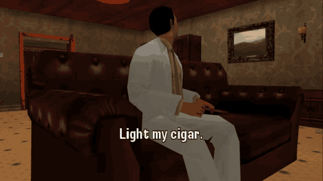 a man in a white suit sits on a couch smoking a cigar