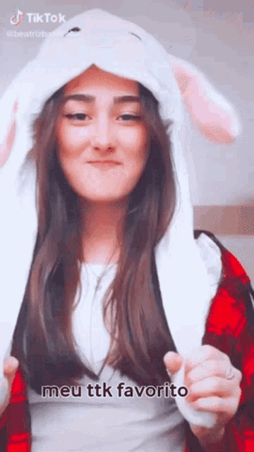 a girl wearing a bunny hat with the words meu ttk favorito on the bottom