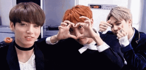 three boys are making a heart shape with their hands .