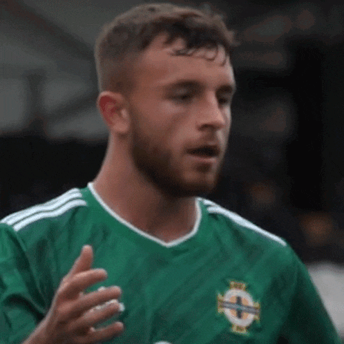 a man with a beard wearing a green soccer jersey