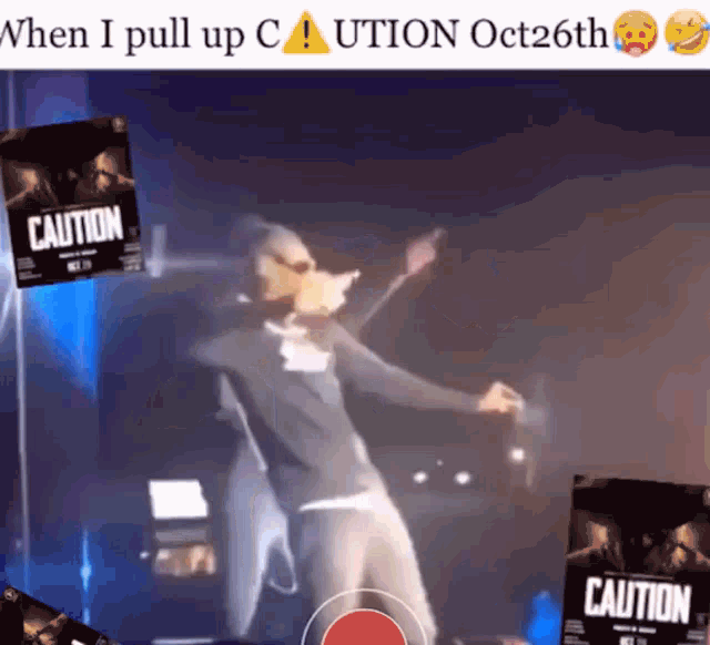 a man singing on a stage with caution posters behind him